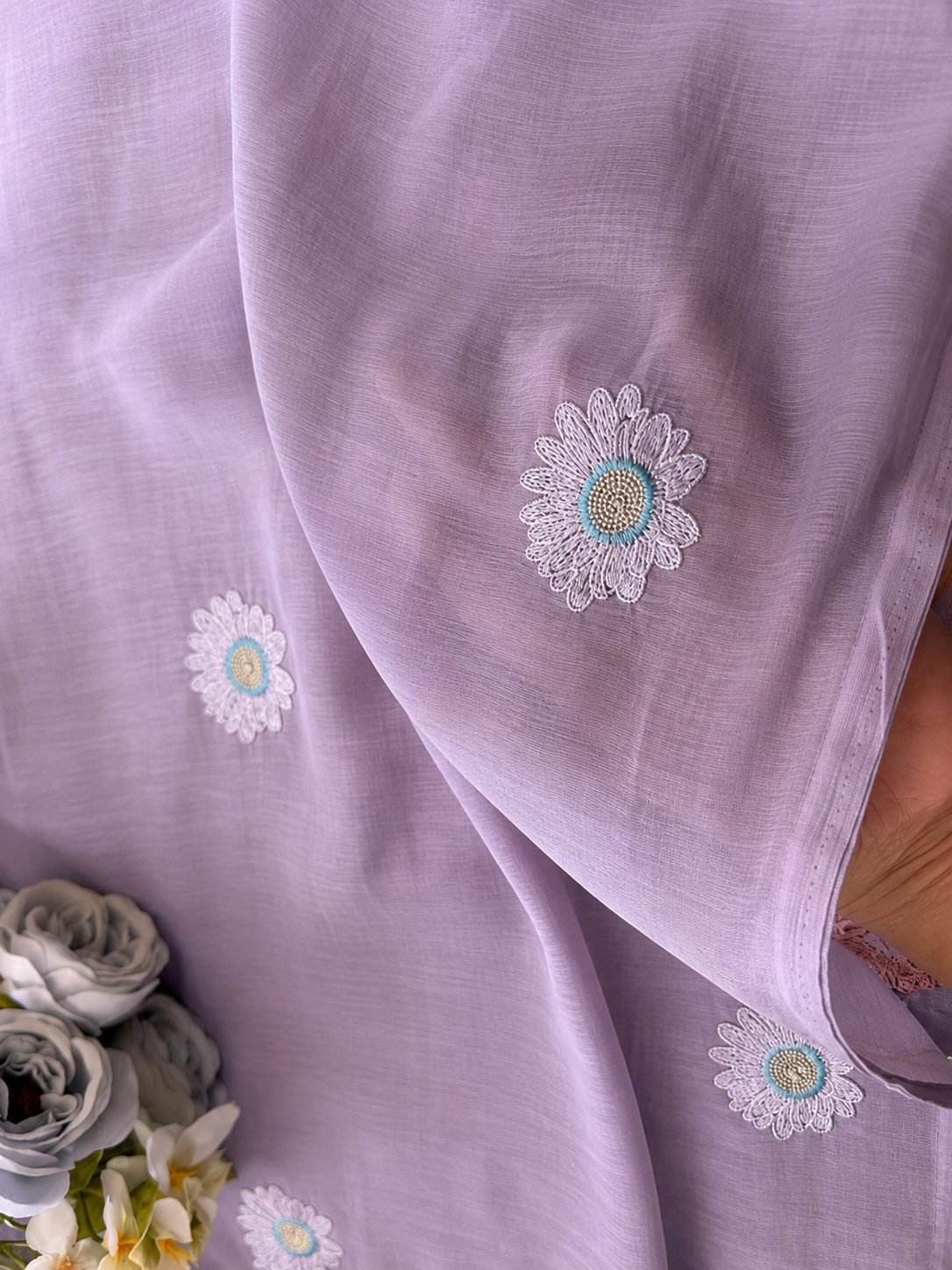 Mauve mul cotton saree with scattered lavender daisy embroidery, styled with soft grey roses.