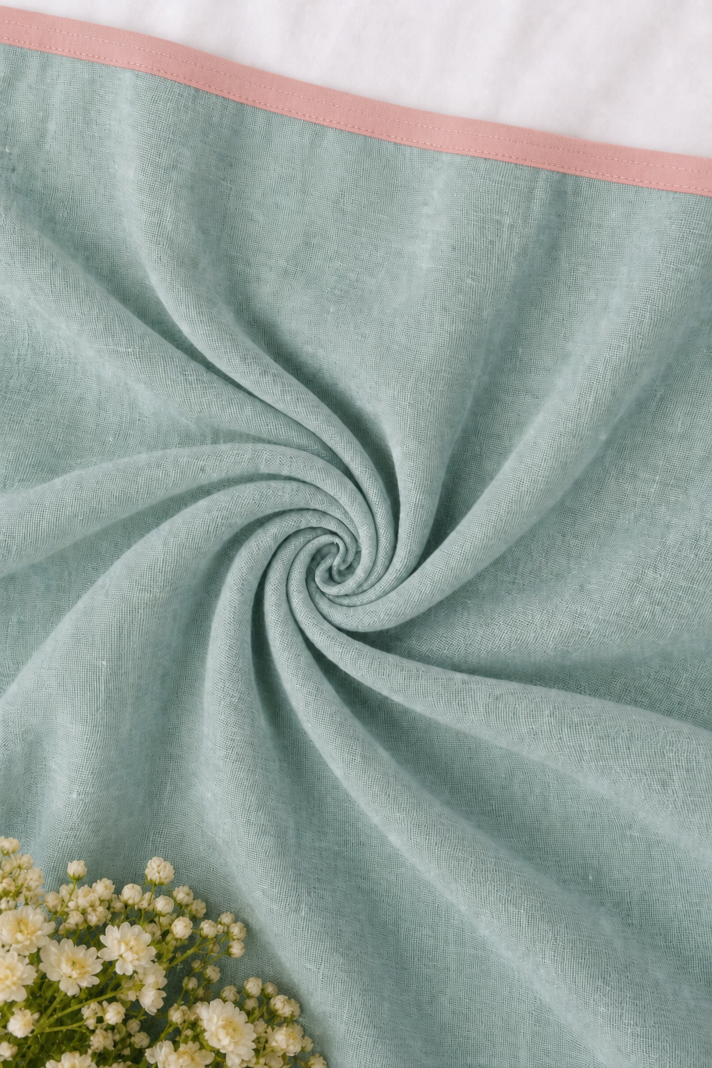 Soft aqua cotton blouse fabric with a blush picot edge, styled in a spiral drape.