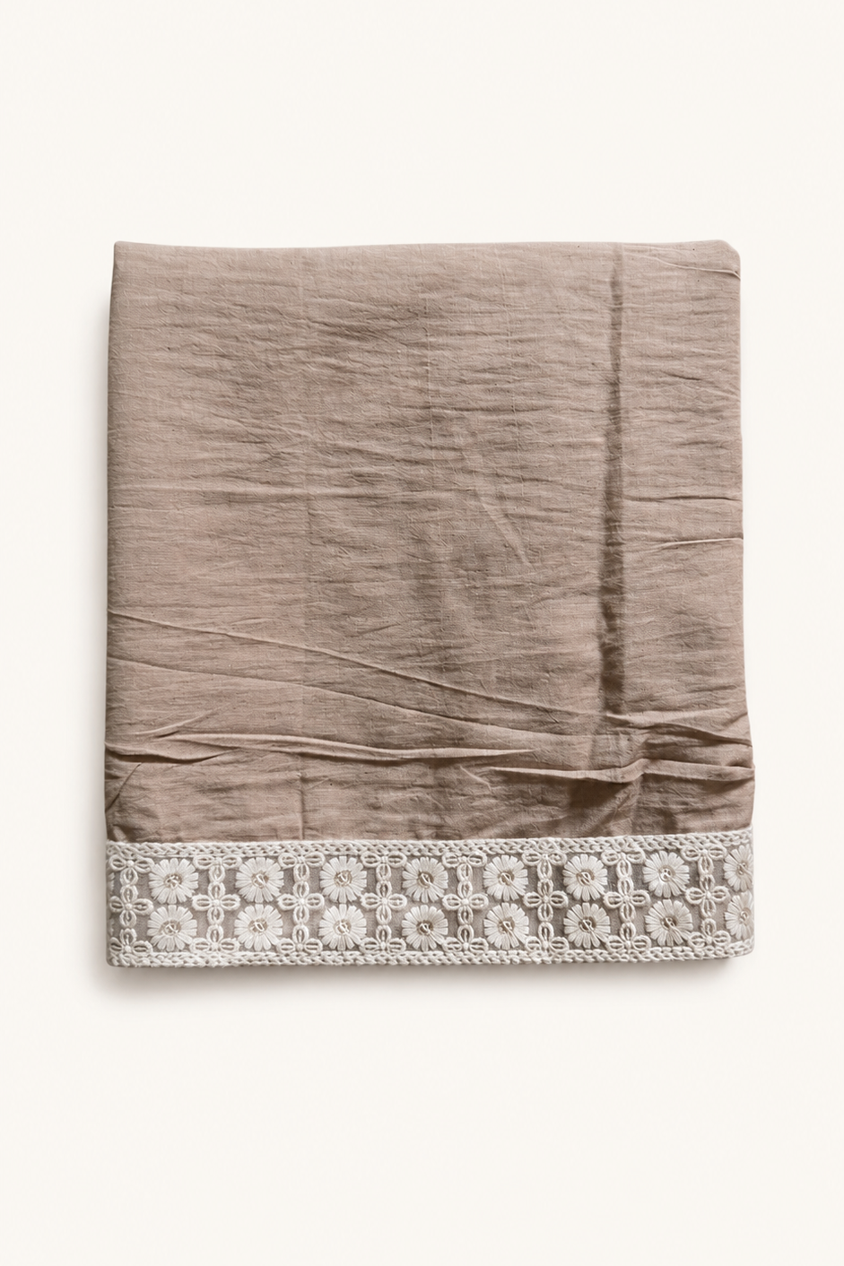 A folded taupe linen fabric item, likely a scarf or throw, featuring a decorative white embroidered border along the bottom edge, set against a plain off-white background.